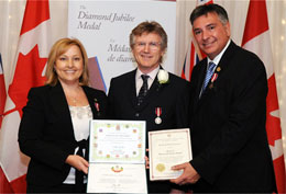 MP Stella Ambler MP and MPP Charles Sousa MPP present Queen's Diamond Jubilee medal to guitarist Rik Emmett. photo by Rob Beintema